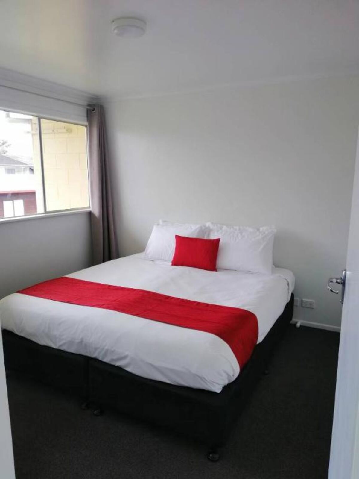 Bright bedroom with a window at Stanley Apartments, Hamilton